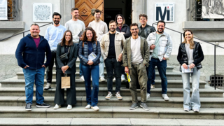 News Gruppe von 13 Personen auf Treppe vor historischem Gebäude