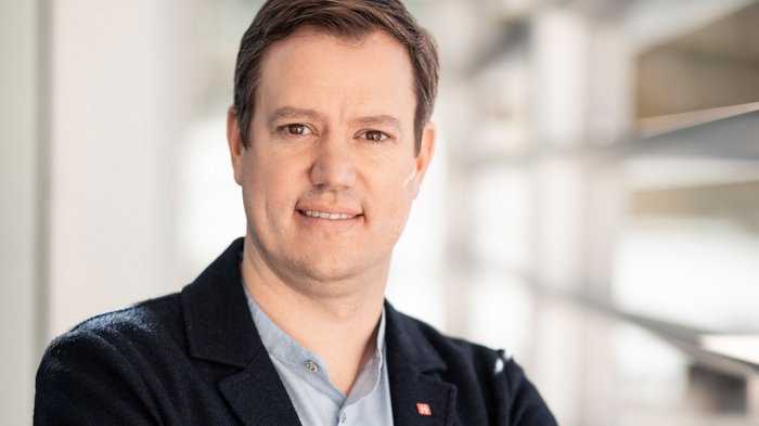 Haller: „Gesundes Maß an Bauprojekten muss möglich sein“ Porträt eines lächelnden Mannes vor einem hellen Hintergrund
