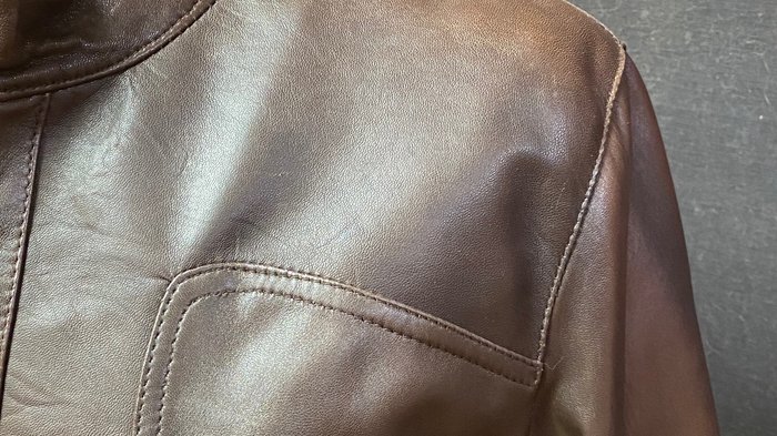 Pellicciai Giacca di pelle marrone con tasca con cerniera e sfondo di tessuto giallo