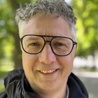 Das Nachhaltigkeitslabel Südtirol Lächelnder Mann mit Brille und grauen Haaren vor unscharfem Parkhintergrund