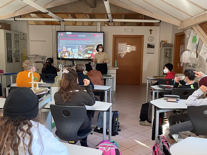 Handwerk und Gastgewerbe: Gut informierte Schüler Schüler im Klassenzimmer hören einer Lehrerin mit Maske zu