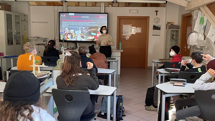 Handwerk und Gastgewerbe: Gut informierte Schüler Schüler im Klassenzimmer hören einer Lehrerin mit Maske zu