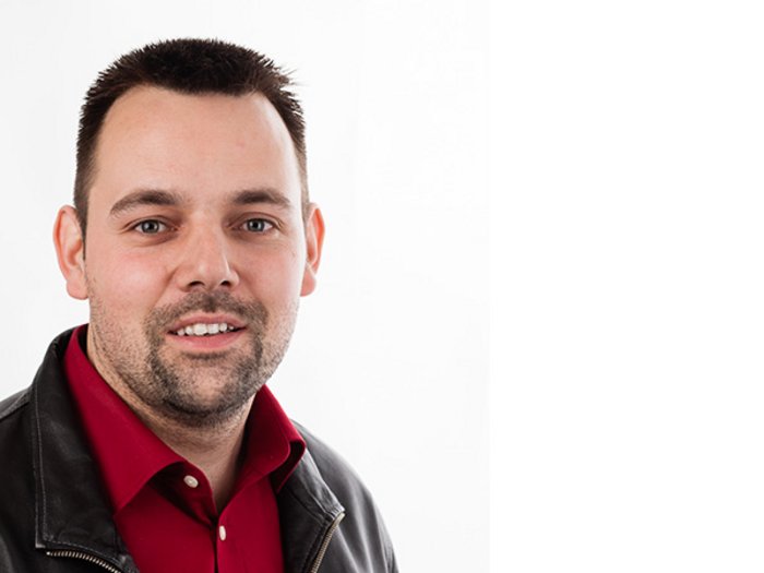 „Die Raumordnung ist ein wichtiges Werkzeug“ Porträt eines lächelnden Mannes mit rotem Hemd und schwarzer Lederjacke vor weißem Hintergrund