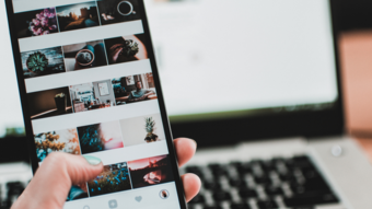 Artigianato sostenibile Mano che tiene uno smartphone con galleria di foto davanti a un laptop