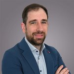 Das lvh-Team Porträt eines Mannes mit Bart in blauem Sakko vor grauem Hintergrund