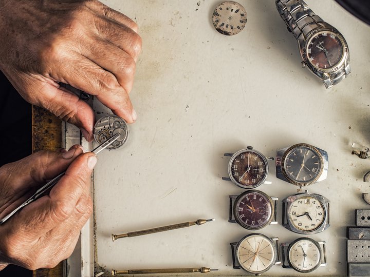 Uhrmacher Uhrmacher repariert alte Uhren mit Werkzeugen auf Werkbank