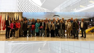 News Gruppenfoto von Erwachsenen vor einem Raum mit mehreren Länderflaggen