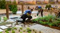 Gold und Medaillon for Excellence für Südtirol Zwei Männer gestalten eine Gartenanlage mit Pflanzen und Holzbelag in einer Halle
