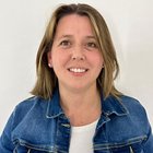 Frauen im Handwerk Porträt einer lächelnden Frau mit blonden Haaren und Jeansjacke vor weißem Hintergrund