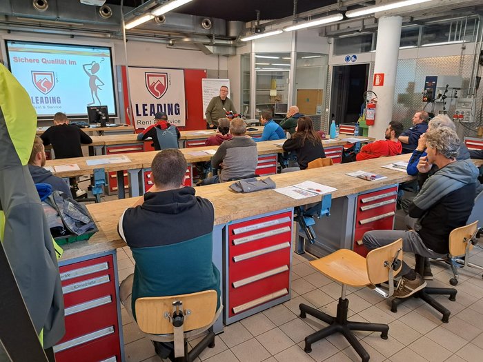 I tecnici per la manutenzione di articoli sportivi si preparano alla stagione sciistica Partecipanti in aula che ascoltano una lezione sulla qualità sicura