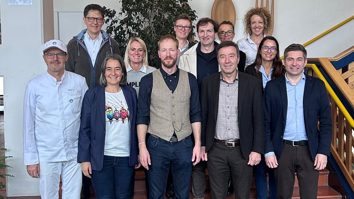 Ortsversammlung Feldthurns: Engagement vor Ort und klare Perspektiven Gruppenfoto von zwölf Personen in Innenraum vor Treppe und Wanddekoration