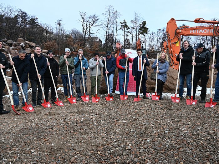 Neue übergemeindliche Gewerbezone stärkt Wirtschaftsstandort im Überetsch Gruppe bei Spatenstich mit roten Schaufeln auf Baustelle mit Baggern