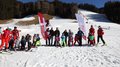 Südtirols erster Handwerker-Snowpark eingeweiht Kinder und Skilehrer posieren auf einer Piste mit zwei Fahnen und Schnee im Hintergrund