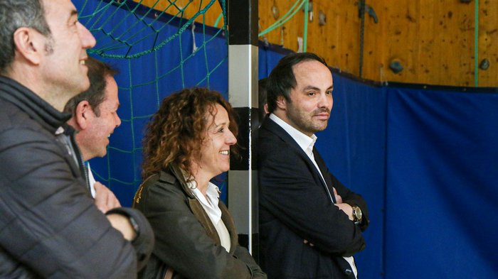 Kreative Spielideen: Preisverleihung für "Clever gebaut" Vier Personen in einer Halle beobachten aufmerksam ein Ereignis mit verschränkten Armen