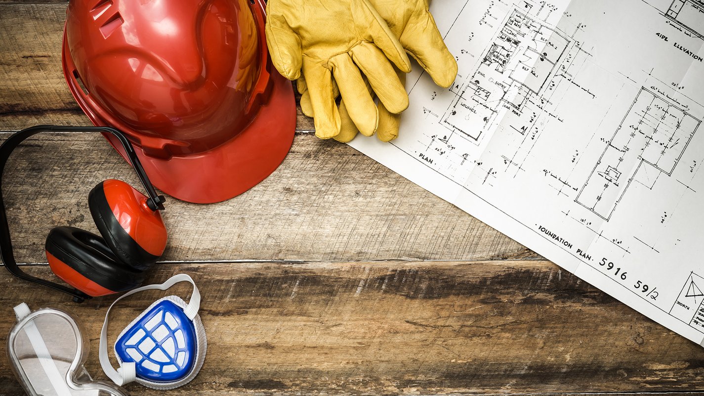 Home Casco da cantiere, guanti, cuffie antirumore, maschera, occhiali protettivi e progetto su tavolo in legno