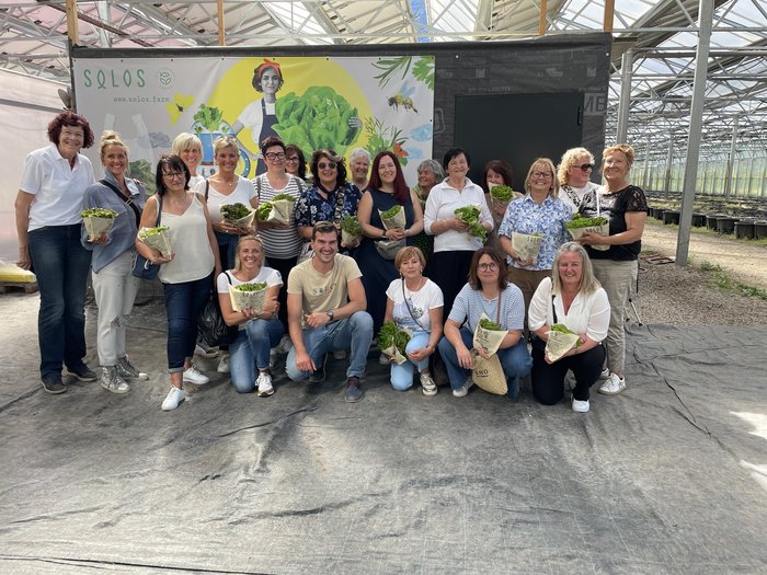 Innovative Einblicke für die Handwerkerfrauen aus dem Oberpustertal Gruppe von Menschen in einem Gewächshaus hält frische Salatköpfe
