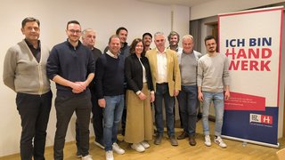 News Gruppe von elf Personen posiert vor Banner mit Text Ich bin Handwerk