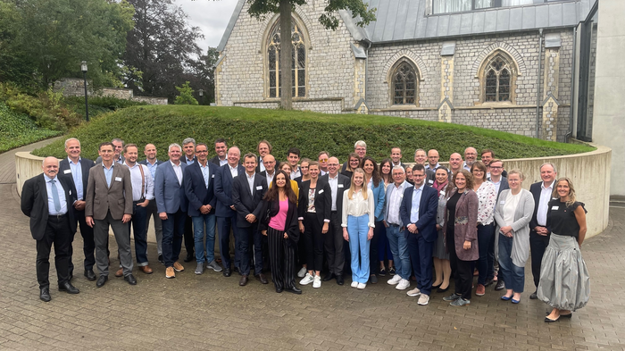 Europäisches Kammertreffen Gruppenfoto von Menschen vor einem Gebäude mit gotischen Fenstern