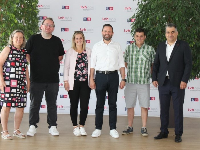 Kurs für zukünftige Mietwagenunternehmer/innen Sechs Personen in einem Raum vor LVH-apa Banner posieren für Foto