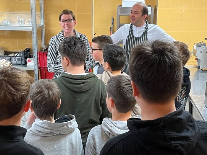 Mittelschule Innichen: Berufe praxisnah erleben Gruppe von Jungen lernt in einer Küche von einer Frau und einem Koch