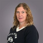 Il team di lvh.apa Ritratto di una donna con capelli ricci e maglione nero su sfondo grigio