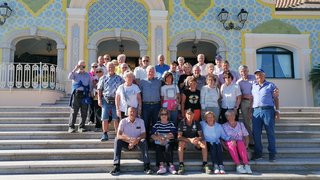 News Große Gruppe älterer Menschen steht auf Treppen vor dekorativem Gebäude
