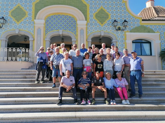 Die Althandwerker/innen im lvh auf Sardinien – Sonne, Meer und ein stiller Moment des Abschieds Große Gruppe älterer Menschen steht auf Treppen vor dekorativem Gebäude