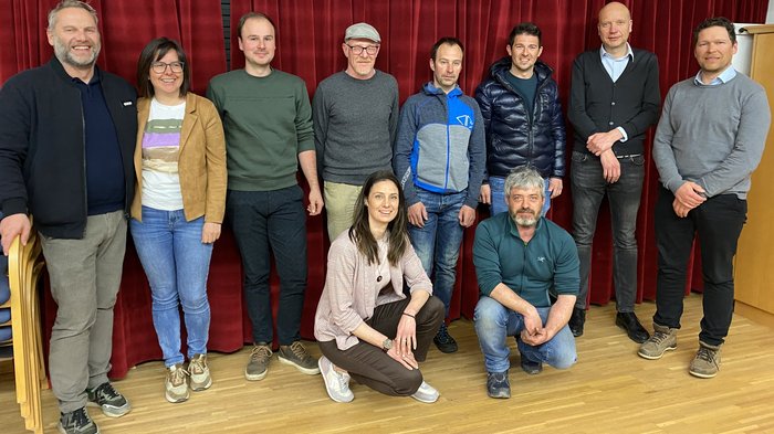 lvh-Ortsversammlung: Handwerk, Innovation und Zukunftsperspektiven Gruppenfoto von zehn Personen vor rotem Vorhang in Innenraum