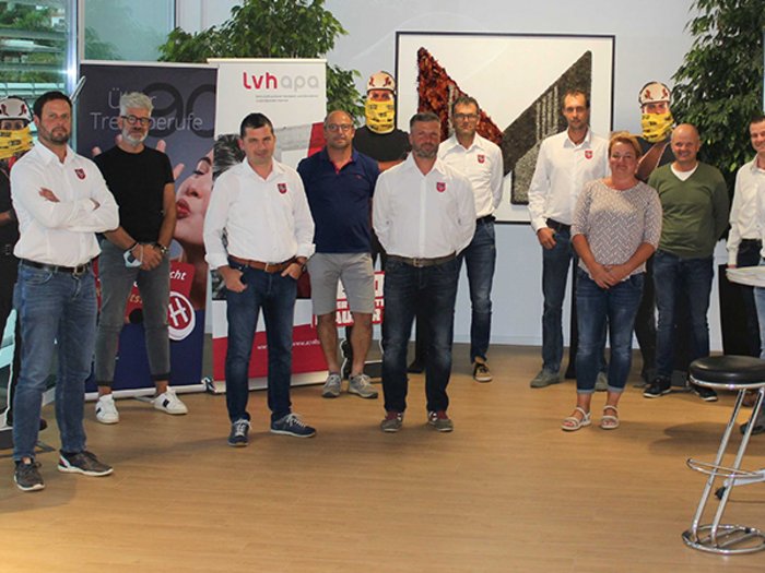 Die Helden der Baustelle: Nachwuchs-Handwerker gesucht! Gruppe von 14 Personen steht in einem Büro mit Bannern im Hintergrund