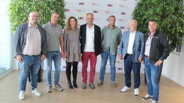 Viele Ehrengäste bei der Jahresversammlung Sieben Personen stehen vor einem LVH-Hintergrund in einem hellen Raum mit Pflanzen