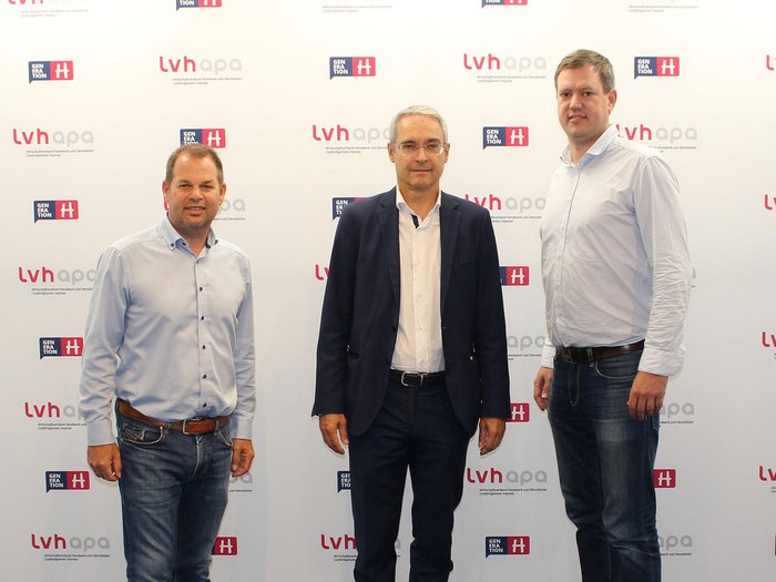© lvh.apa Drei Männer stehen vor einer Wand mit lvhapa und Generation H Logos