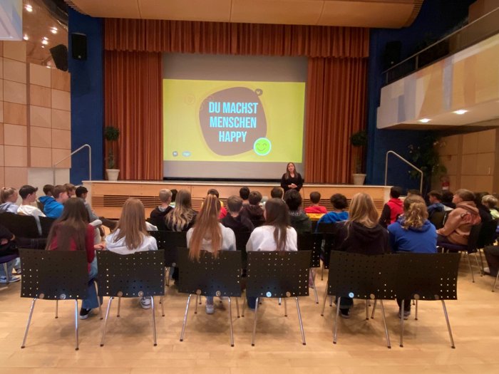 Esplorare il mondo delle professioni pratiche Studenti ascoltano una presentazione in aula con il messaggio Tu rendi felici le persone