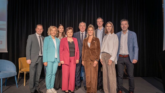 Crescita in equilibrio Nove persone in abbigliamento formale posano su un palco con sfondo nero