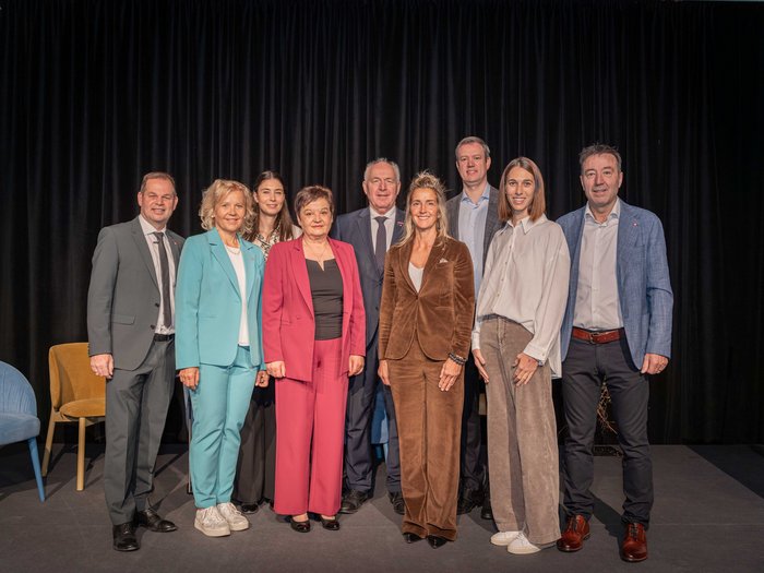 Crescita in equilibrio Nove persone in abbigliamento formale posano su un palco con sfondo nero