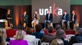 La 31^ Fiera d’Arte UNIKA apre le porte a Ortisei Panel di sei persone in discussione davanti al pubblico con logo Unia sullo sfondo