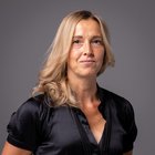 Frauen im Handwerk Porträt einer blonde Frau mit schwarzen Bluse vor grauem Hintergrund