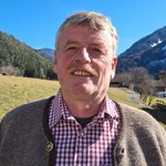 Brixen Lächelnder Mann vor Berglandschaft an einem sonnigen Tag