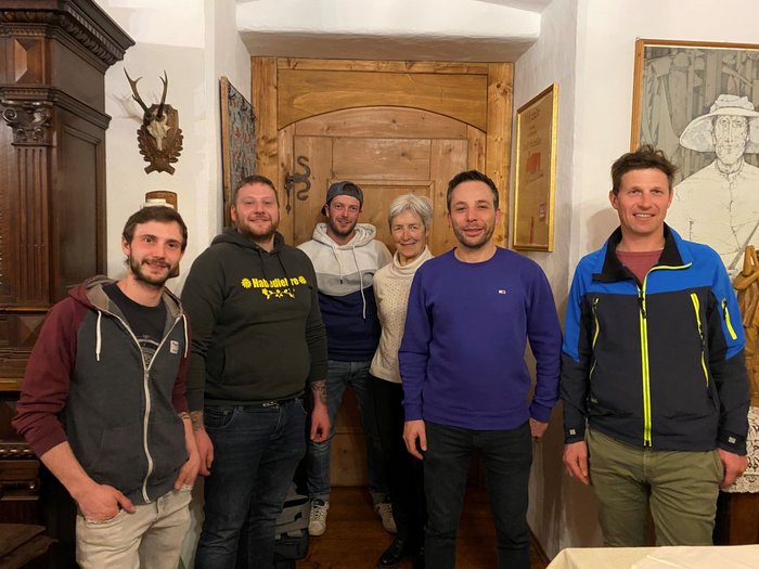 Beständigkeit beim Handwerk in Barbian Sechs Personen stehen vor einer Holztür in einem gemütlichen Raum