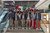 Un gruppo con giacche grigie e cappelli posa su una scalinata con una bandiera italiana