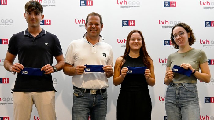 Berufsschüler/innen für das Handwerk begeistern Vier Personen halten blaue Etuis vor einer lvhapa und Generation H Wand