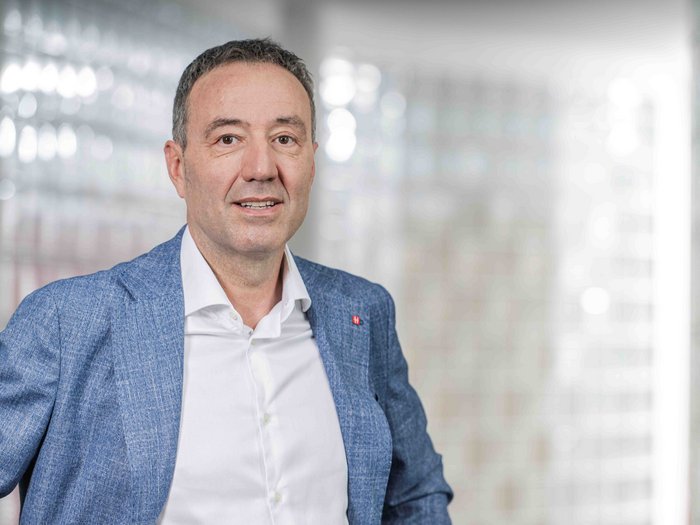 Werbesteuer in Südtirol: Staat ermöglicht höheres Inkasso – aber wo bleibt der Bürokratieabbau? Mann im blauen Anzug vor unscharfem Hintergrund