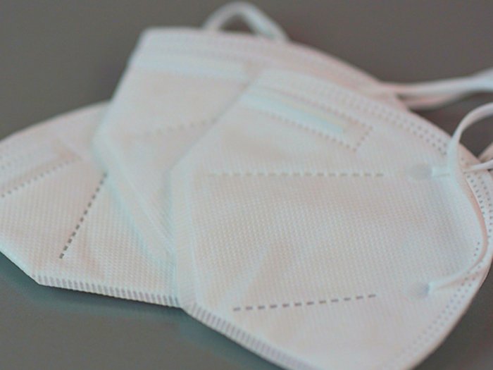 FFP2-Masken für Südtirols Schönheitspfleger Drei weiße FFP2-Masken auf grauem Untergrund