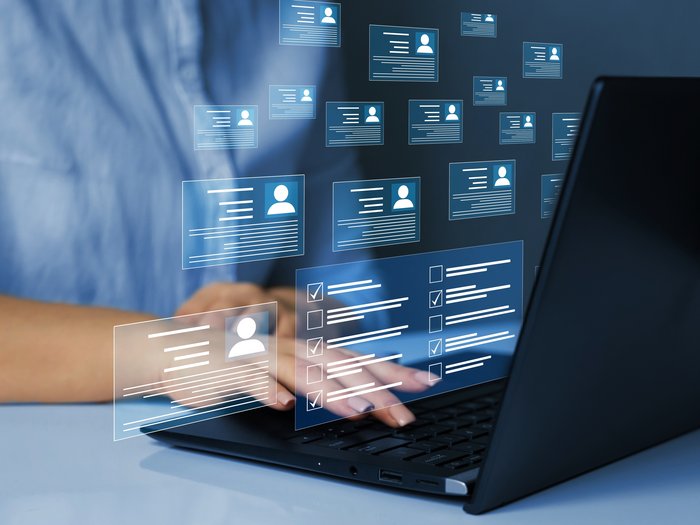 Lieferantenregistrierung in Vergabeportalen: Was Betriebe jetzt wissen müssen Person arbeitet am Laptop mit digitalen Profil- und Datenanzeigen