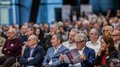 Intelligenza artigiana: nuove opportunità grazie all‘IA Pubblico a una conferenza legge il programma e ascolta attentamente