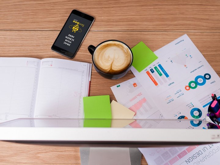 Percorso formativo Postazione di lavoro con computer, smartphone, caffè, appunti e grafici su scrivania di legno