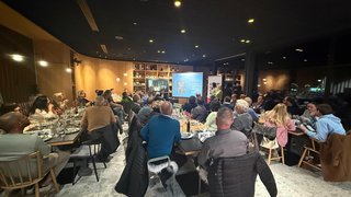 News Persone in un ristorante assistono a una presentazione su uno schermo