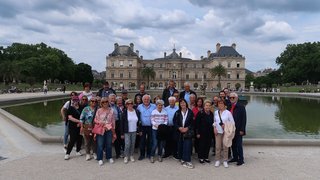News Gruppenfoto vor einem großen historischen Gebäude und einem Teich im Park
