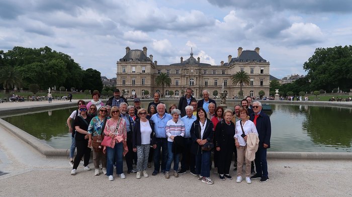 lvh-Seniorinnen und Senioren auf Frühlingsreise: Paris, mon amour! Gruppenfoto vor einem großen historischen Gebäude und einem Teich im Park