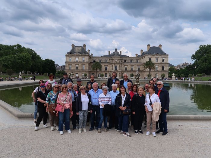 lvh-Seniorinnen und Senioren auf Frühlingsreise: Paris, mon amour! Gruppenfoto vor einem großen historischen Gebäude und einem Teich im Park