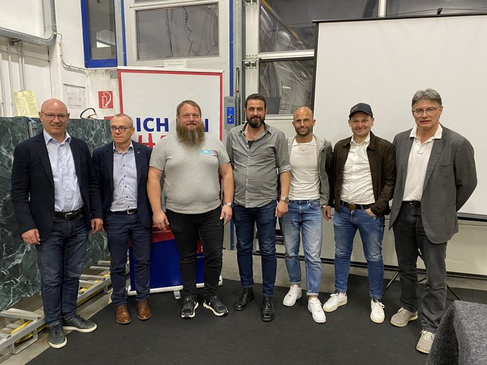 Gran successo della riunione circondariale di lvh.apa a Chiusa Sette uomini in abbigliamento casual e formale in piedi in fila in un ambiente interno